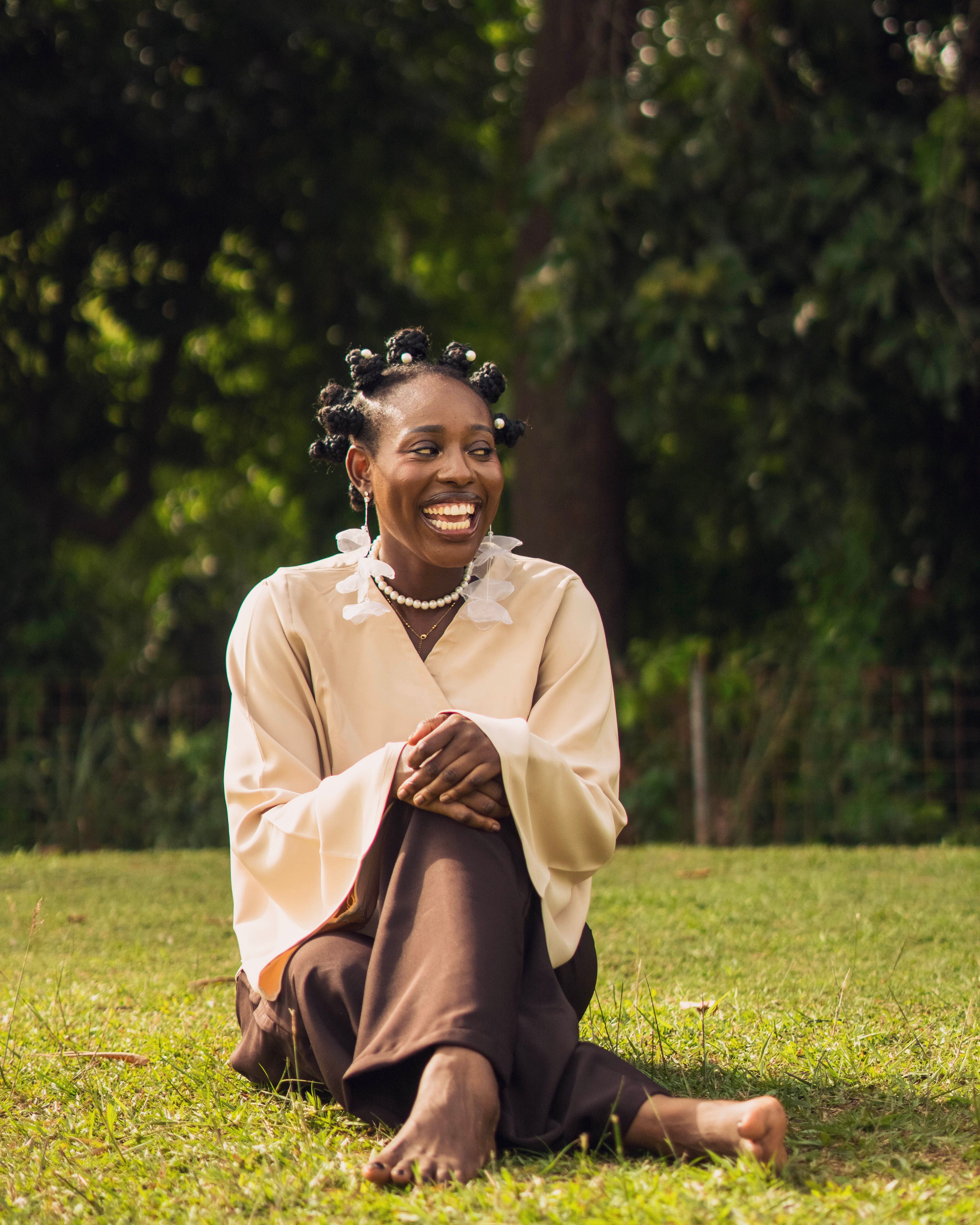 Smiling Woman Sitting Outdoors in Sunlight · Free Stock Photo