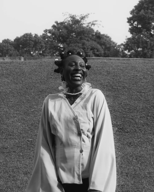 Free Black and white photo of a cheerful woman laughing in a field. Stock Photo