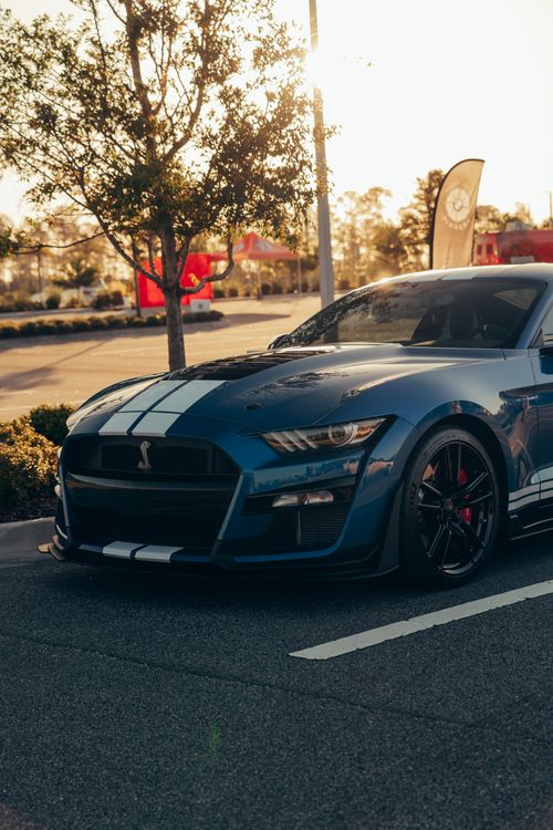 Free Blue sports car parked outdoors during sunset, showcasing sleek design. Stock Photo