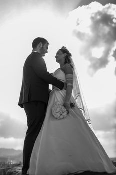 Romantic black and white wedding photo capturing a couple in a scenic outdoor setting.