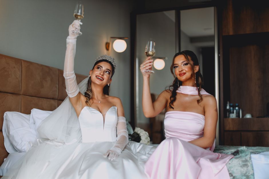 Happy bride celebrating her luxury wedding gown selection with a glass of mimosa Happy bride celebrating her luxury wedding gown selection with a glass of mimosa