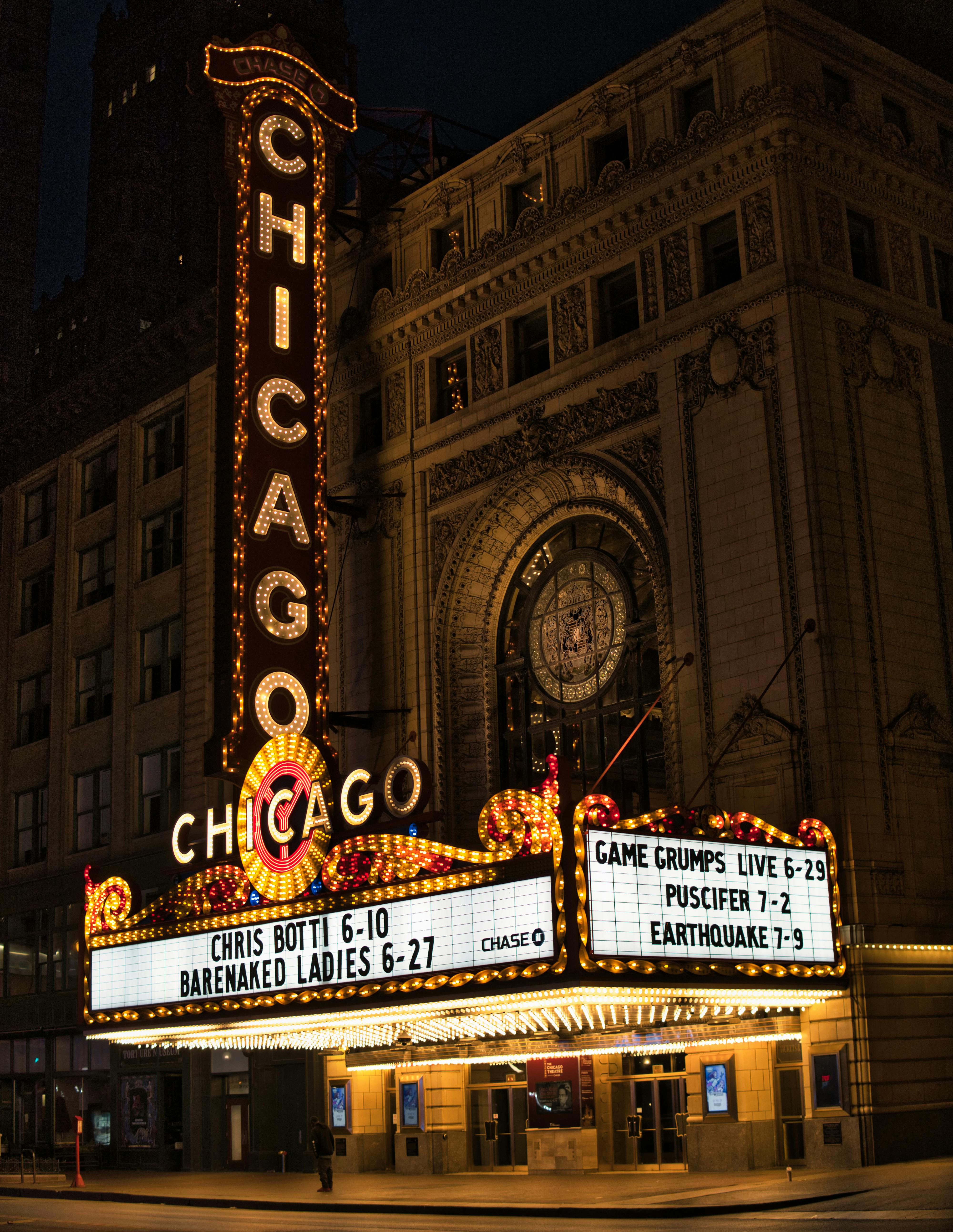 grátis Uma vista cativante da histórica marquise do Chicago Theater iluminada à noite. Foto profissional