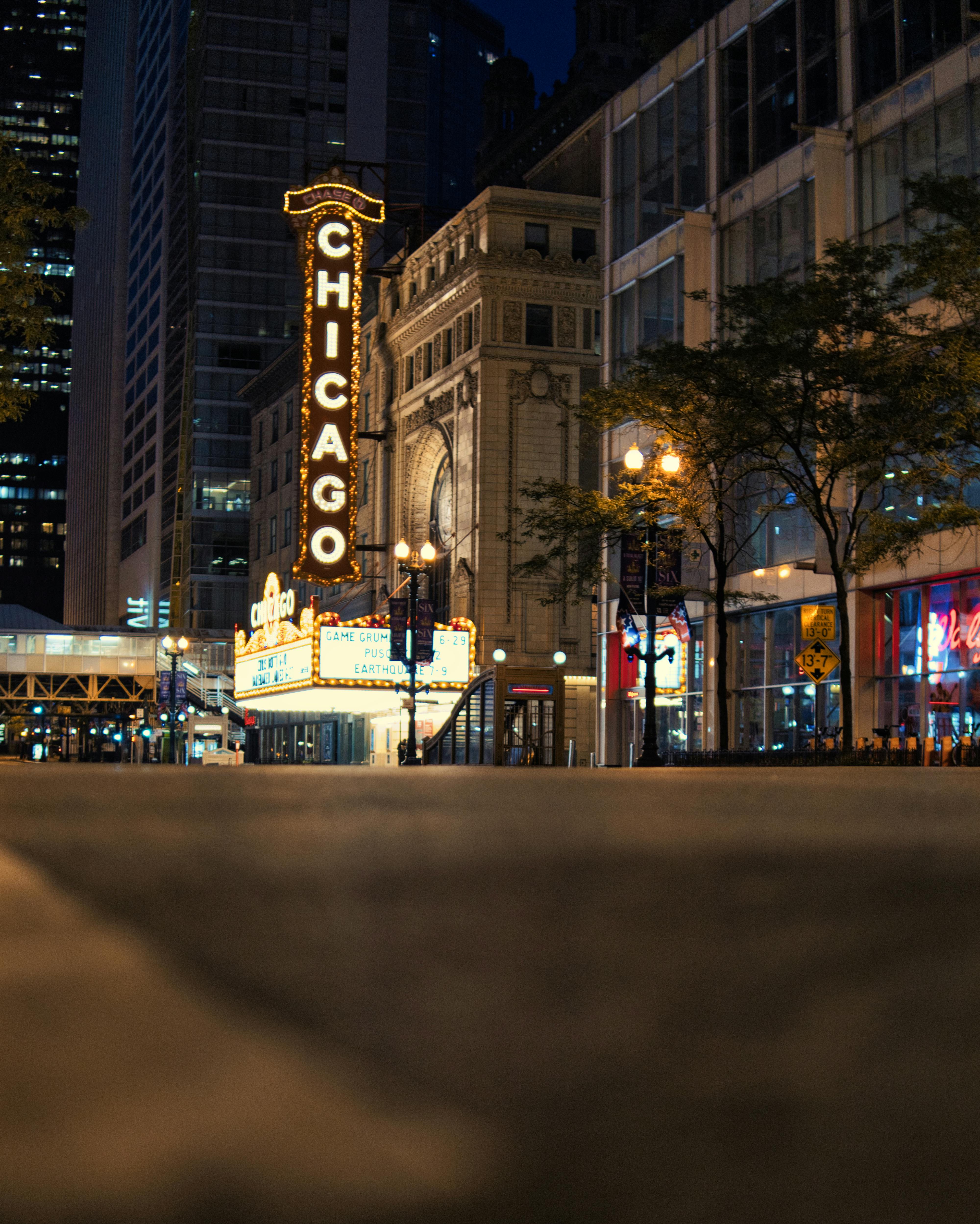 Gratis Tanda Teater Chicago yang ikonik bersinar di kawasan pusat kota yang ramai di malam hari. Foto Stok