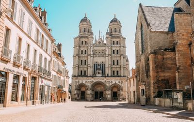 Belle basilique et rue charmante à Dijon, France sous un ciel bleu éclatant.