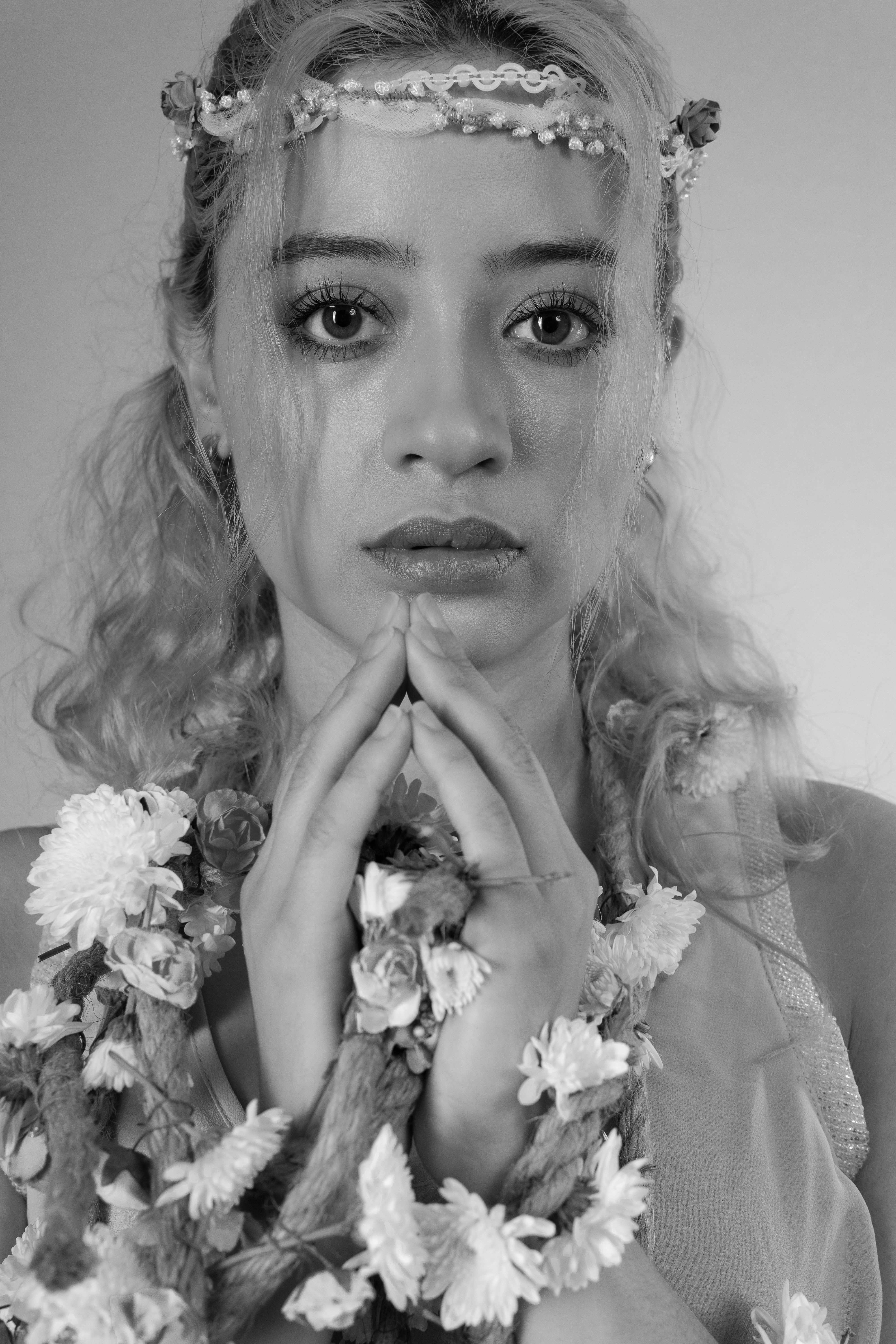 Elegant portrait of a contemplative ballet dancer adorned with flowers, exuding grace.