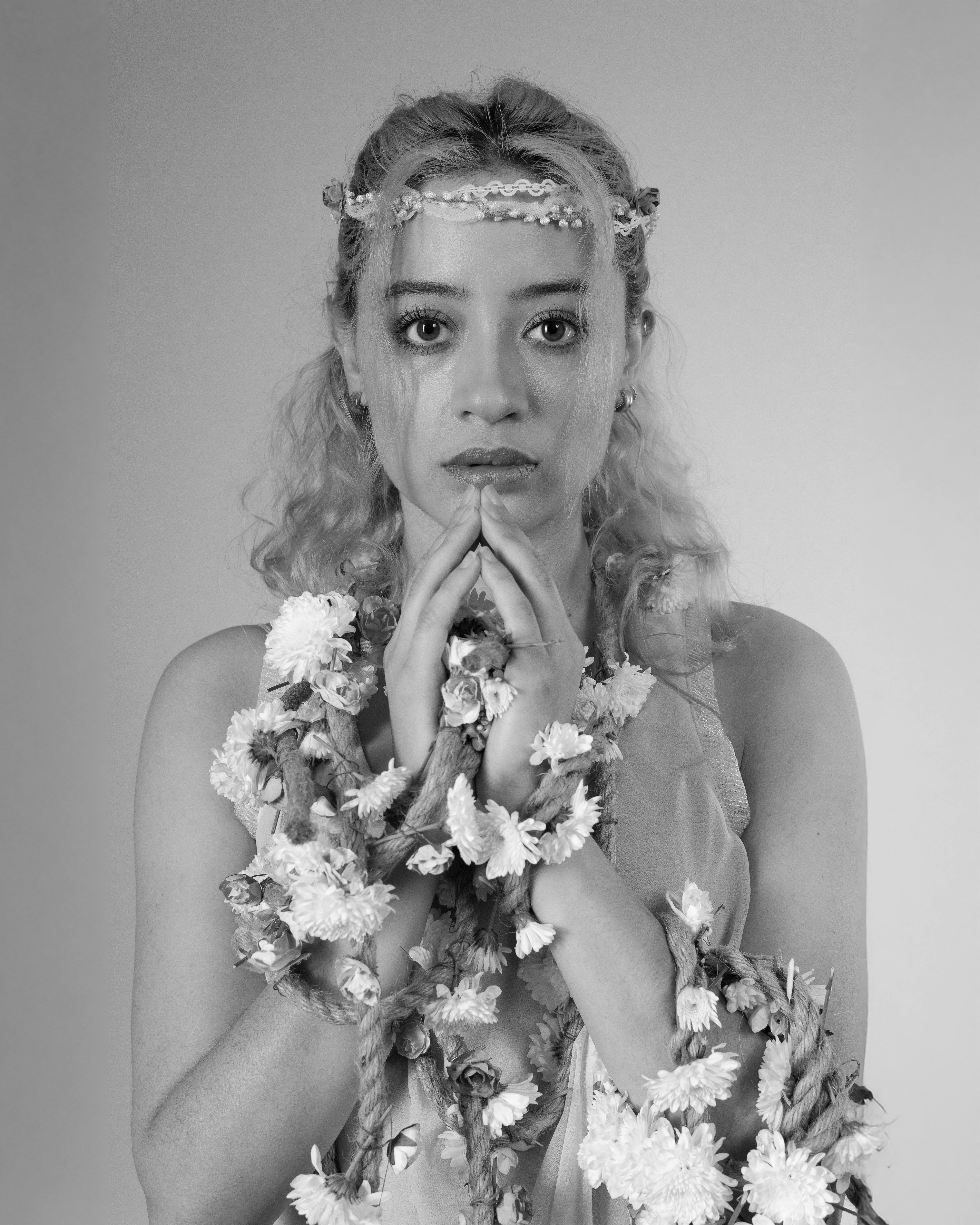 Black and white portrait of a dancer with floral garlands, exuding grace and elegance.