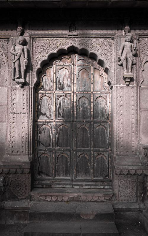 Free Stone arch door with intricate carvings and sculptures on a historic structure. Stock Photo