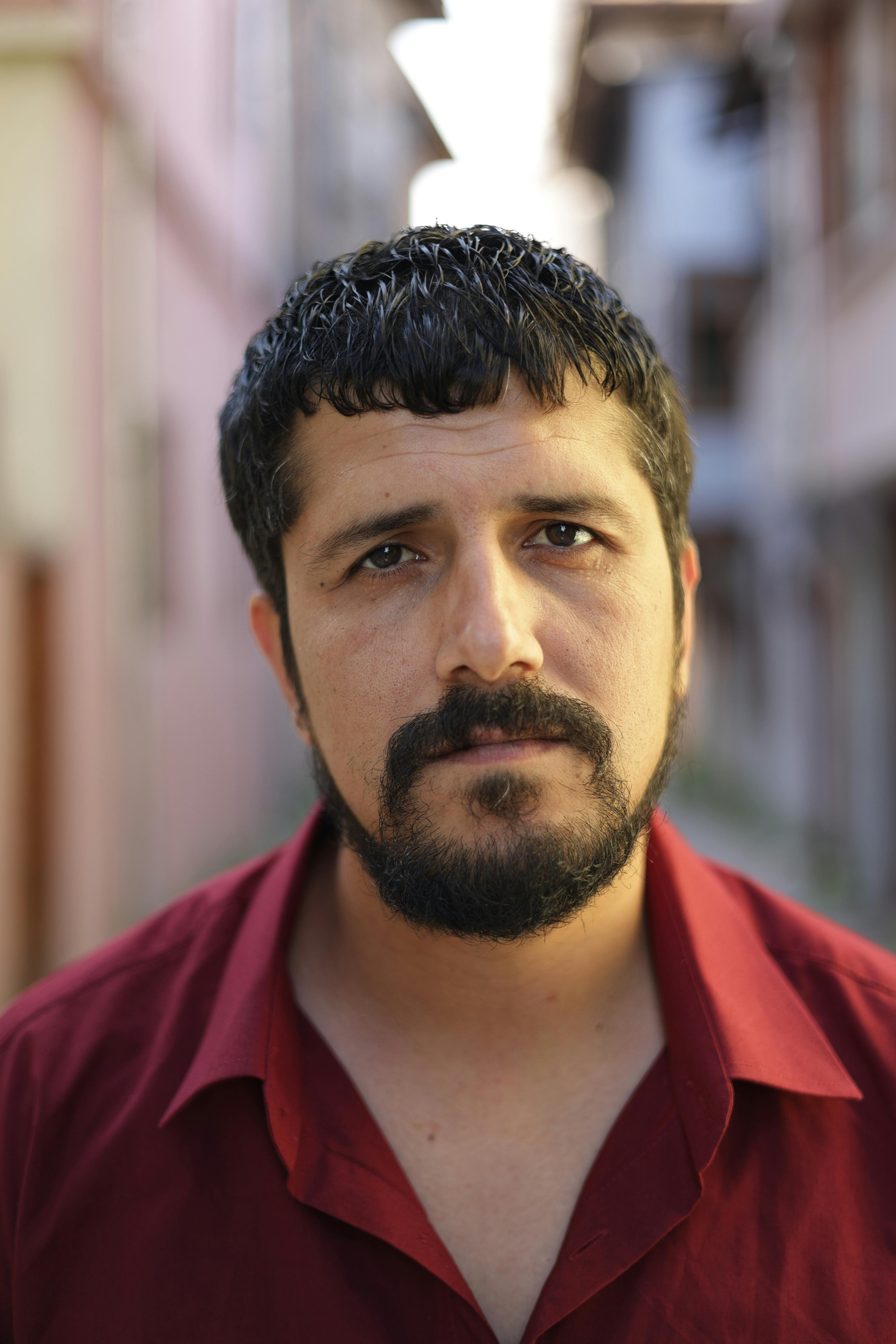 A thoughtful man poses in a historic Turkish street, capturing cultural essence and mood.