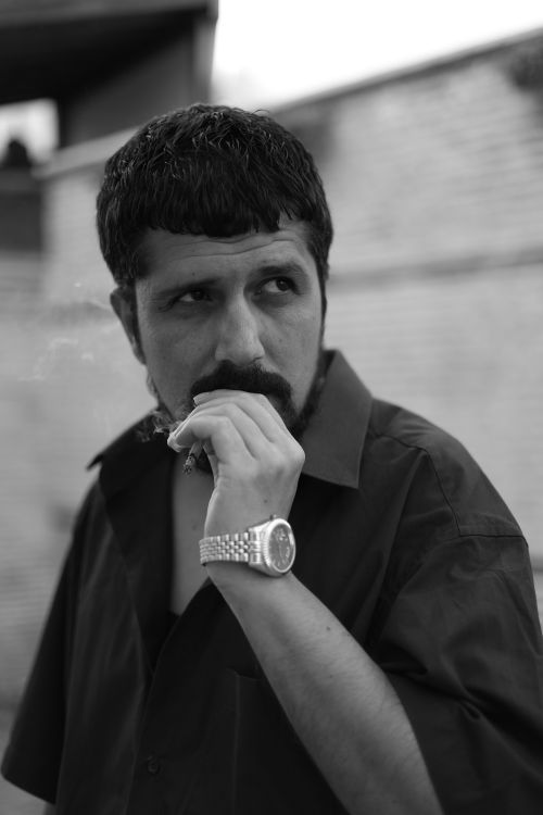 Free Black and white portrait of a man smoking thoughtfully outdoors in Türkiye. Stock Photo