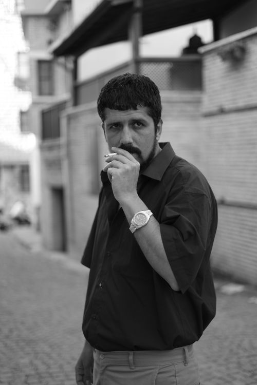 Free A contemplative man smoking in a Turkish street, captured in black and white. Stock Photo