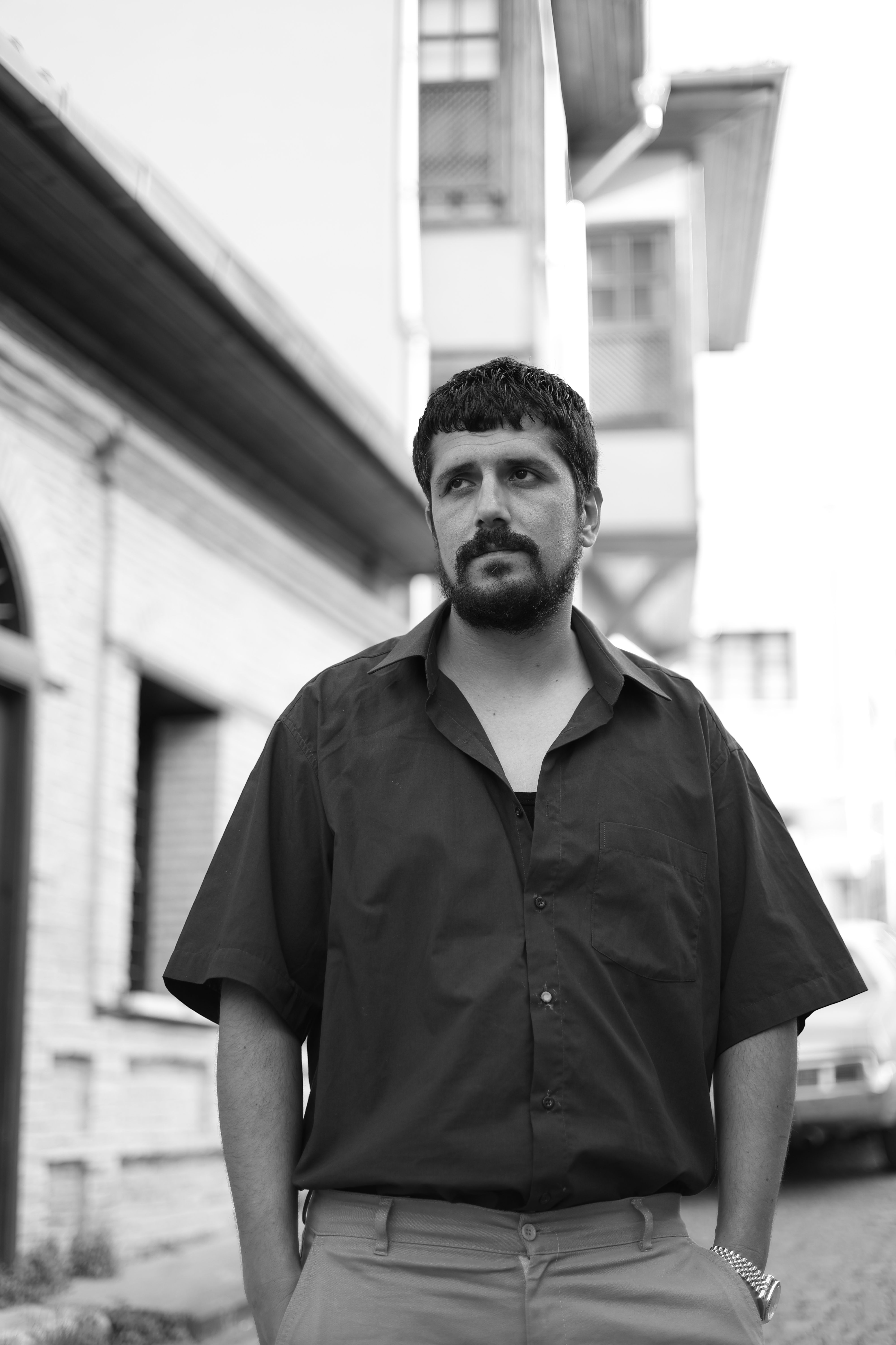 Monochrome street portrait of a man standing in an urban neighborhood in Türkiye.