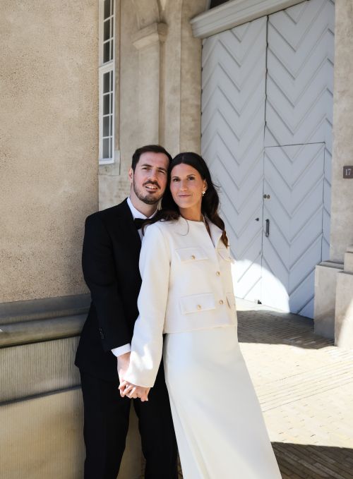 Free An elegant couple in formal attire posing outside a classic building in Copenhagen, Denmark. Stock Photo