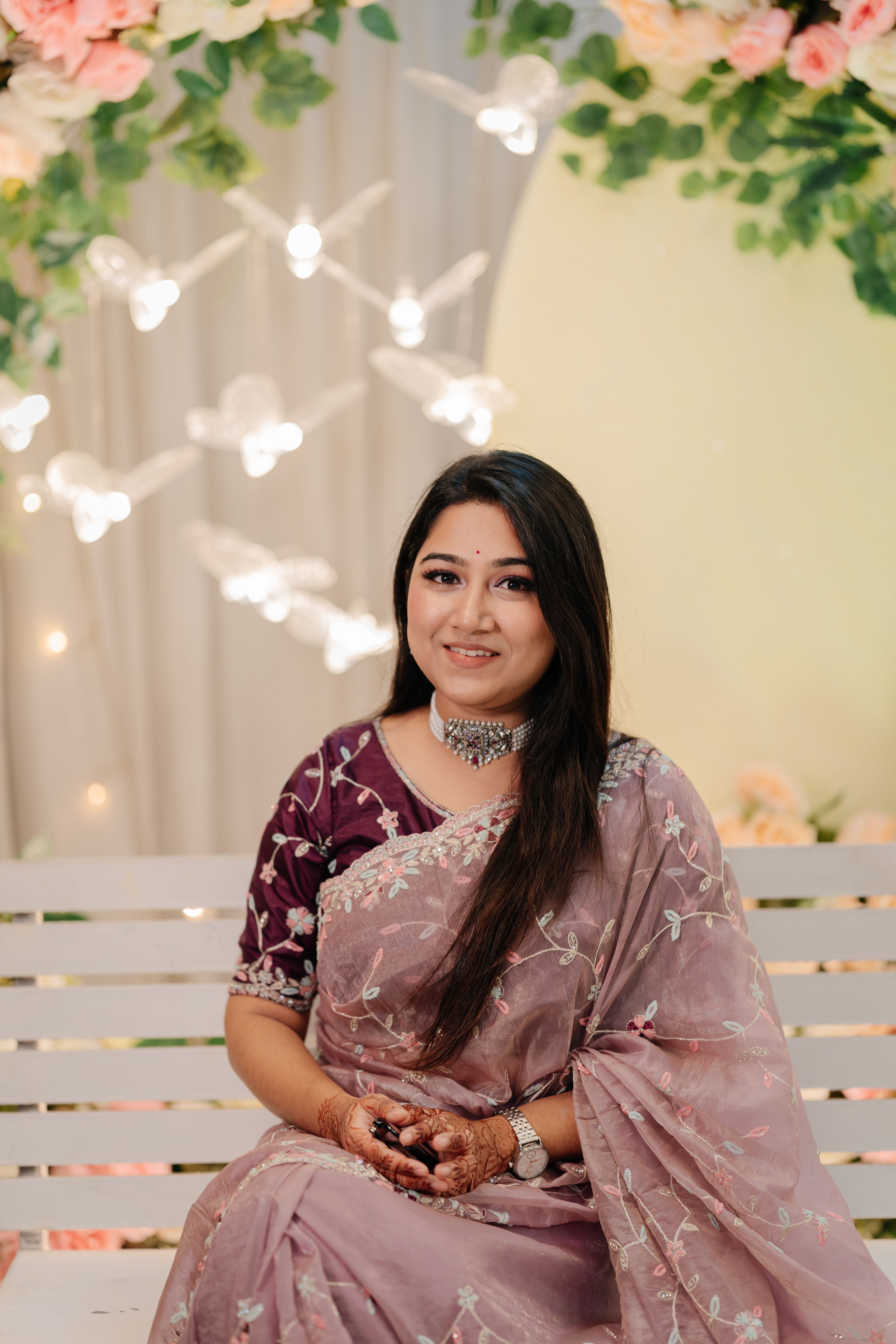 Portrait of a woman in a traditional Indian saree with elegant decor.