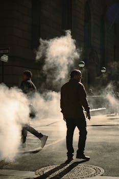Silhouetted urban scene with steam rising in New York City's financial district.