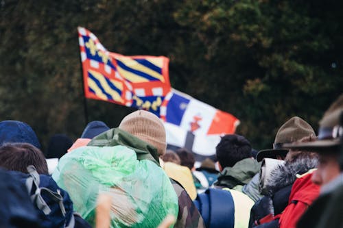 Люди собираются в поле с флагами