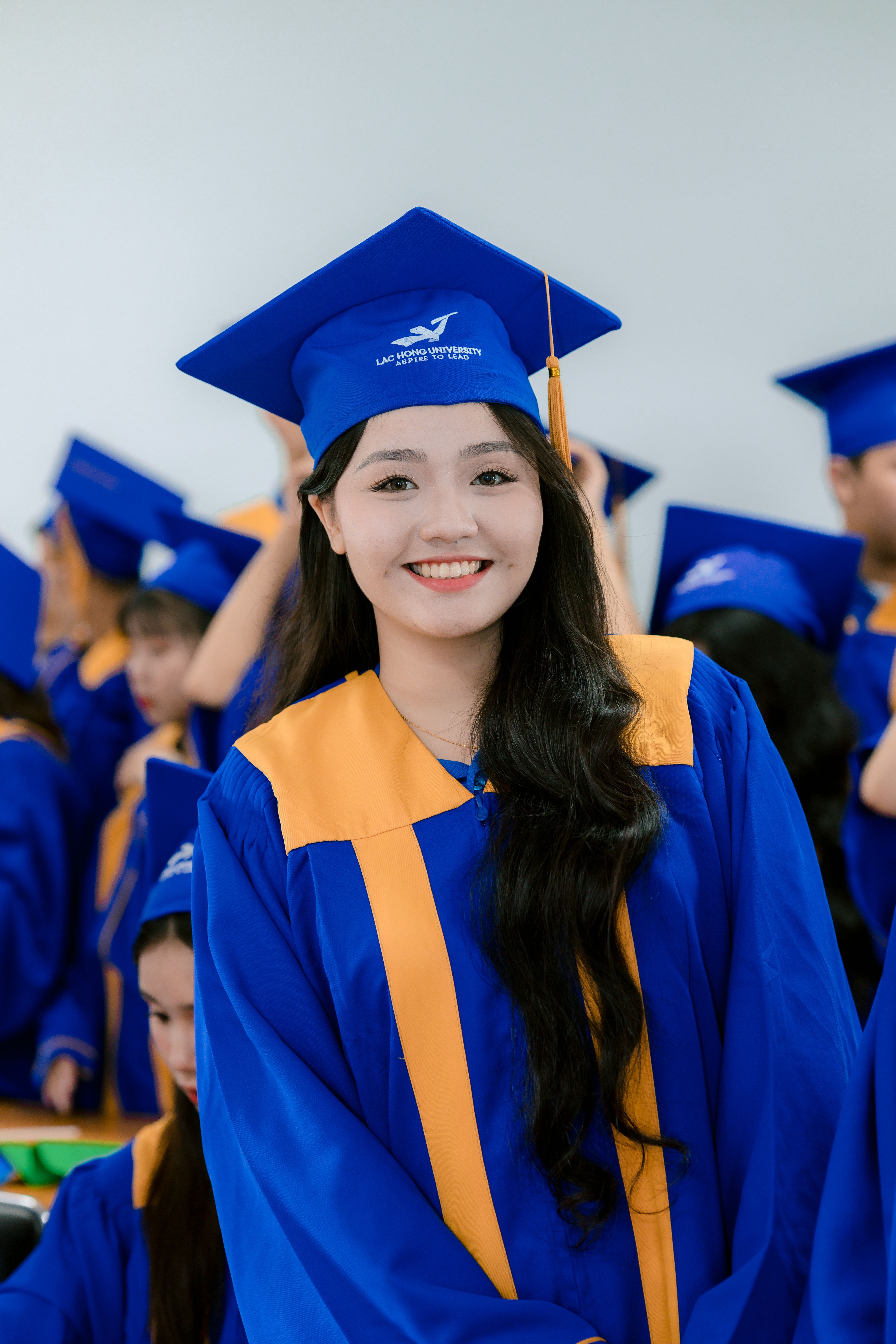 Smiling graduate in blue cap and gown at ceremony · Free Stock Photo