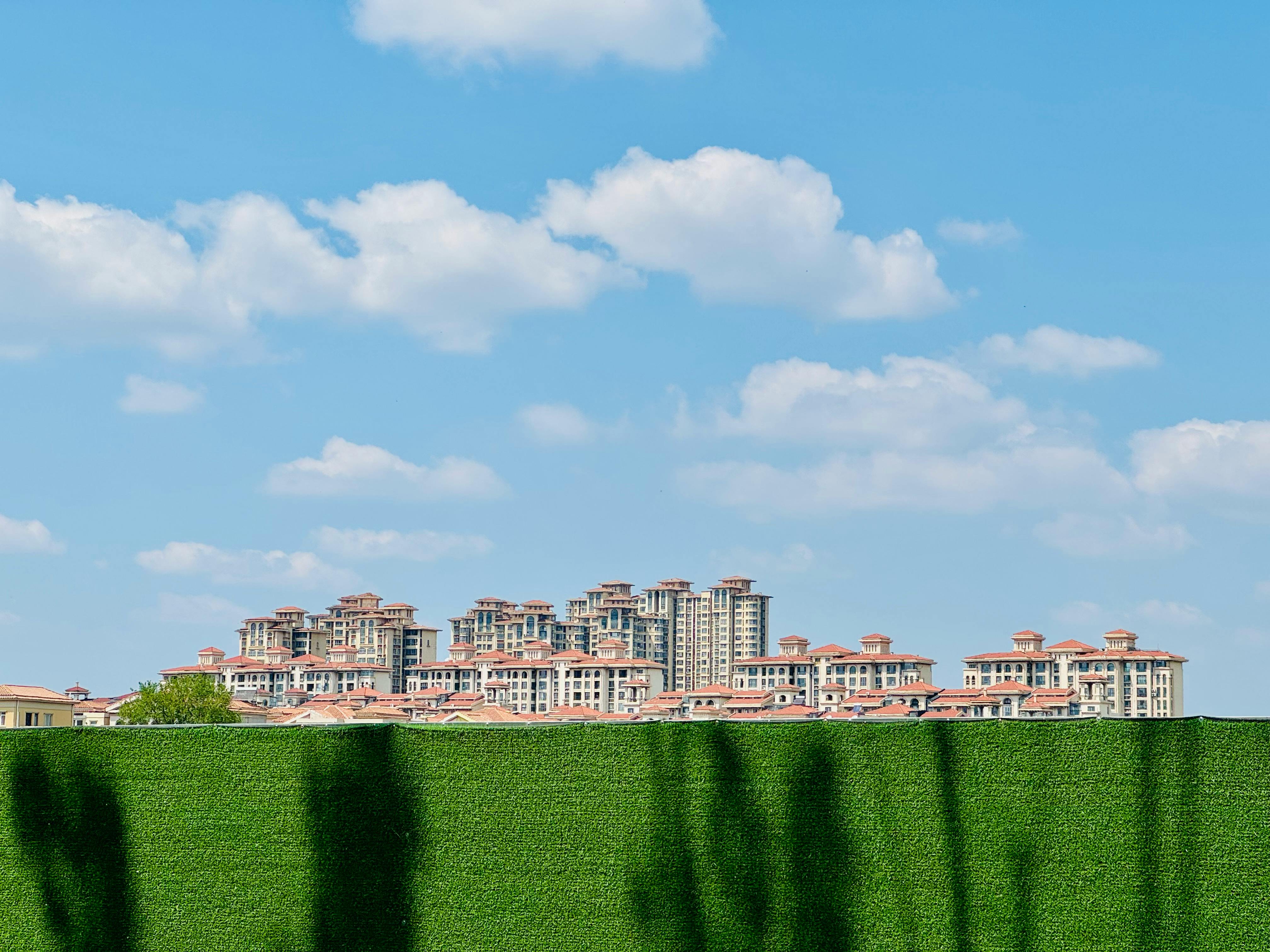 View of a modern apartment complex under a clear blue sky in Tianjin, China.