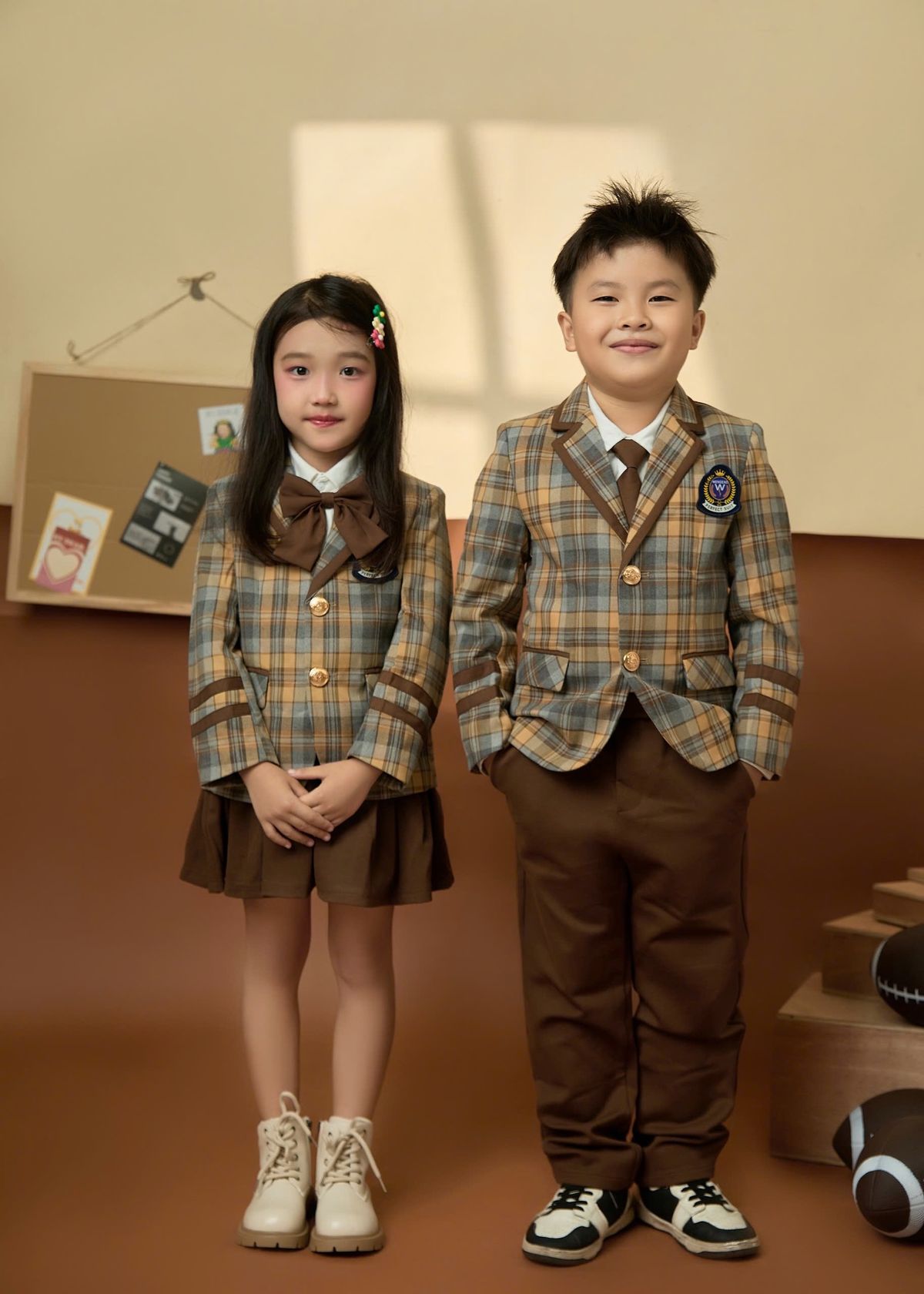 East Asian children in school uniforms standing indoors