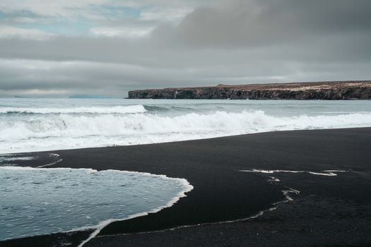 Waves crash on the black sand shores of a remote Iceland beach.. waves, crash, black