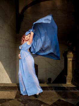 Dramatic portrait of a woman in a flowing blue dress capturing grace and beauty.