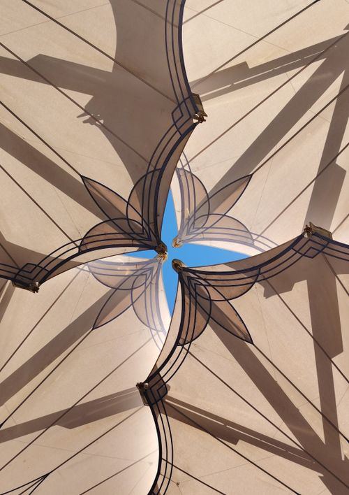 Free Intricate ceiling design with geometric patterns and a glimpse of blue sky. Stock Photo