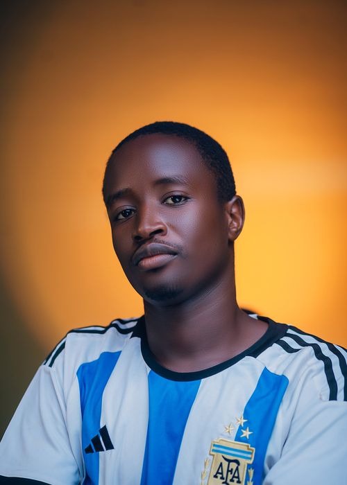 Free A thoughtful man in a striped sports jersey poses against a warm gradient background. Stock Photo