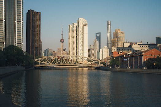 Stunning view of Shanghai's skyline featuring famous landmarks and Waibaidu Bridge during sunset.