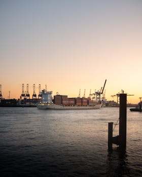 A serene view of a container ship in Hamburg harbor during sunset, highlighting the industrial beauty.