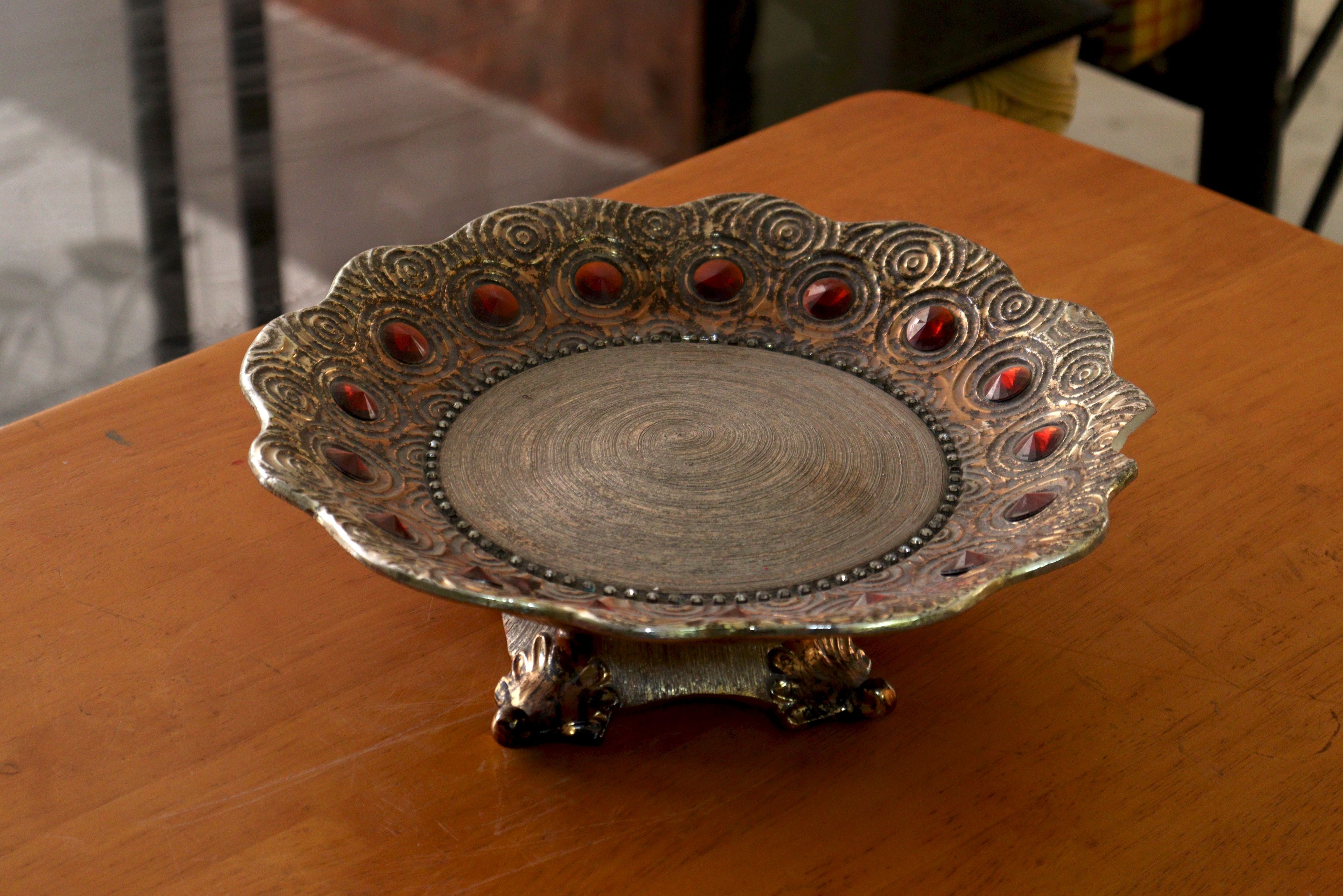 Elegant metal plate with ornate design on wooden table, capturing intricate craftsmanship.