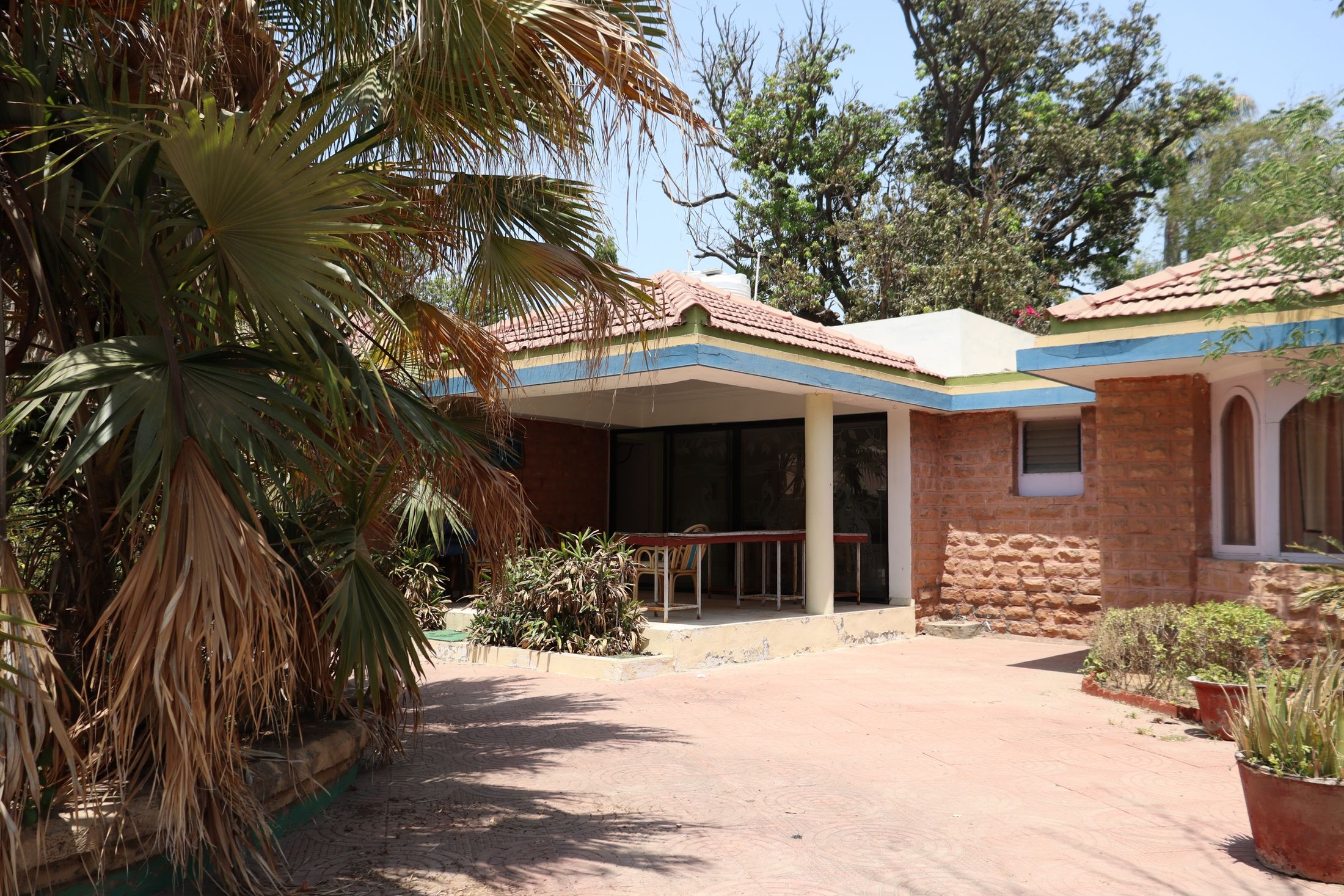 Traditional home with earth-and-brick walls and a tiled roof in a garden