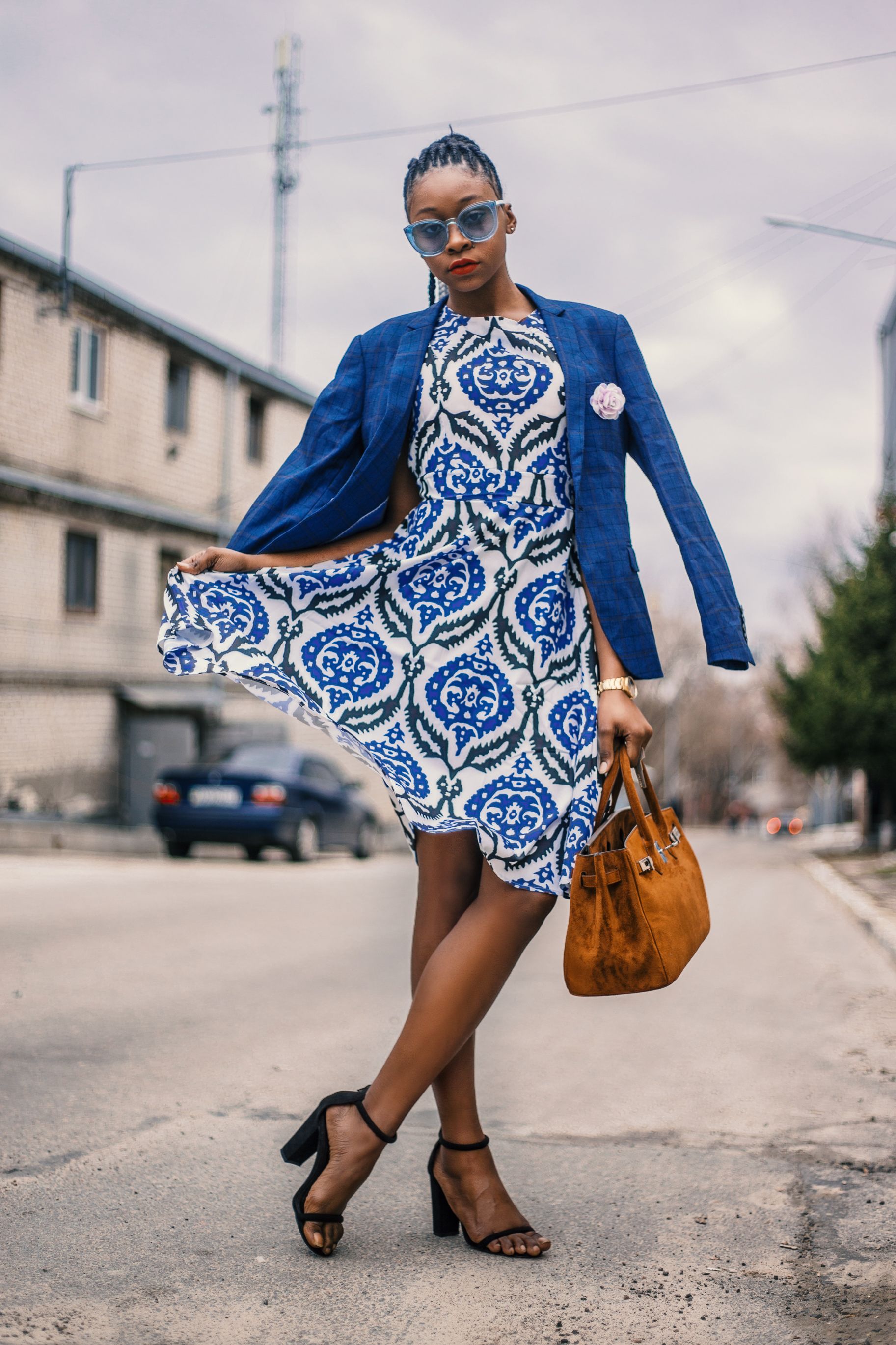 Mulher fashionista posa ao ar livre com roupa azul, mostrando estilo.