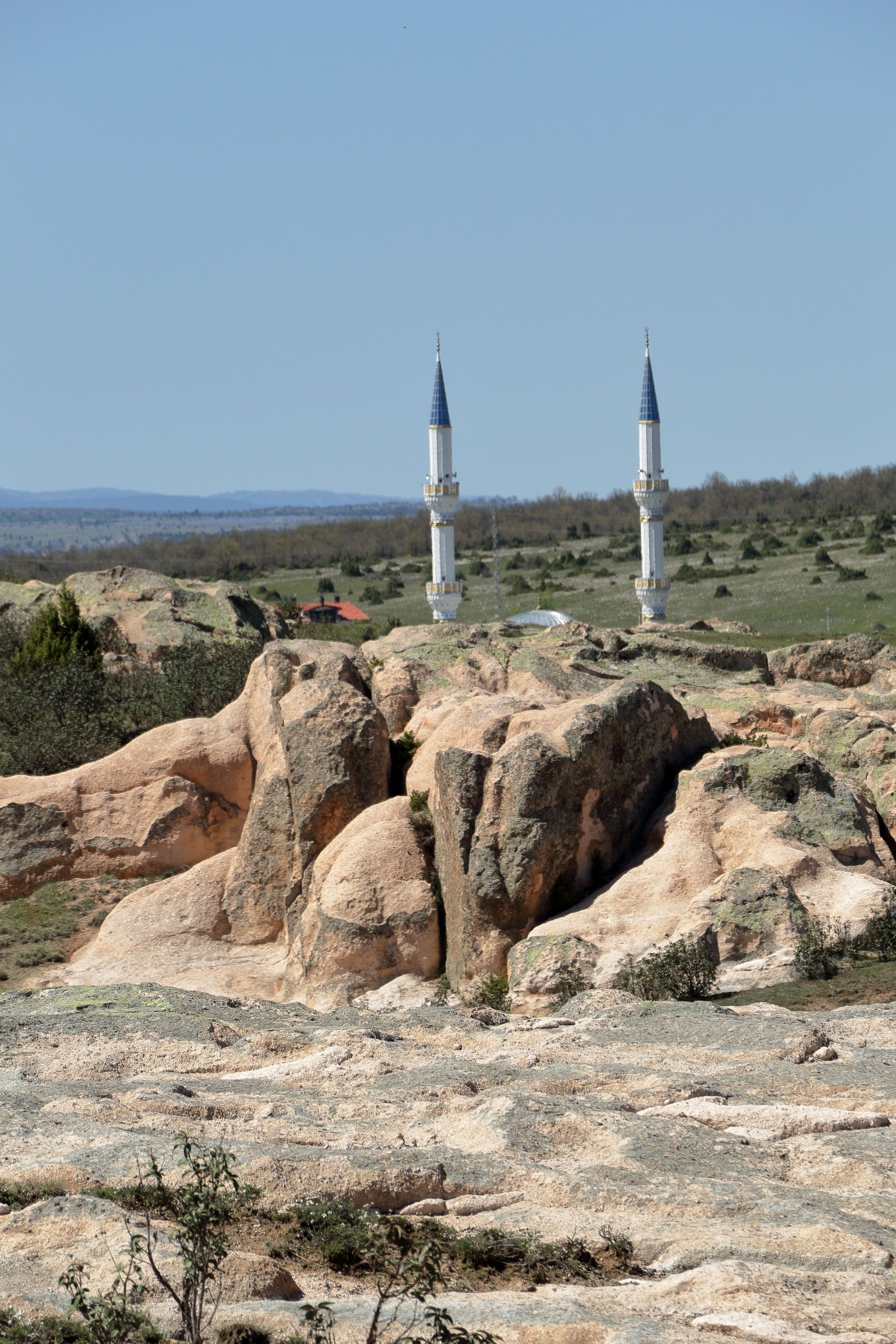 Beautiful scenic view featuring twin minarets amidst rocky formations under a clear sky.