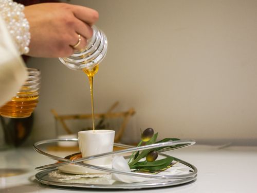 Free A hand elegantly pouring honey into a small Turkish tea cup. Perfect for cultural and culinary themes. Stock Photo