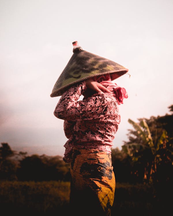 Free Person Holding and Wearing Hat Stock Photo