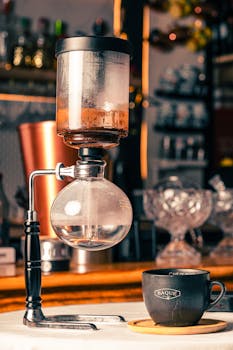 A vintage coffee siphon brewing setup on a café counter, creating artisan coffee drinks.