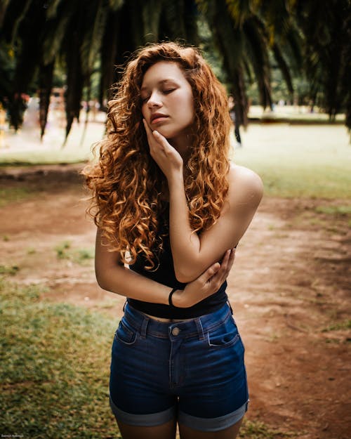 Dreamy woman with perfect skin standing on dry walkway