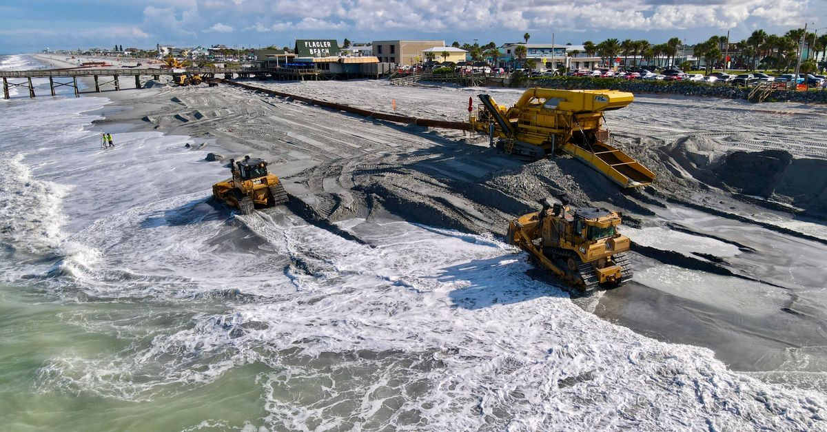 Heavy machinery working at Flagler Beach, showcasing beach restoration near the pier.