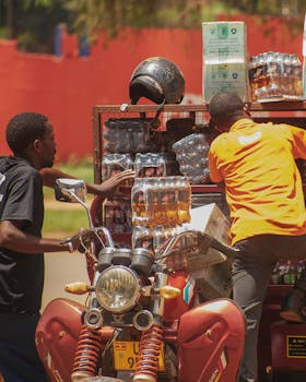 Two men loading a motorcycle with beverage crates for delivery, innovative urban logistics.