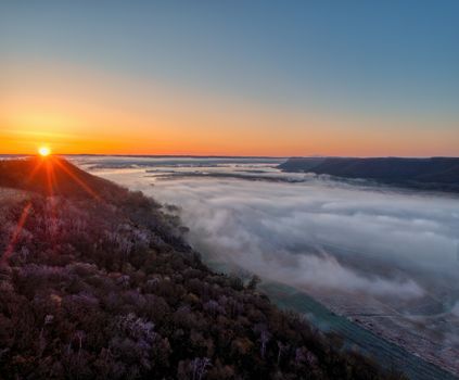 A stunning aerial view of sunrise casting light over a misty valley in Weaver, Minnesota.