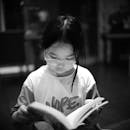 Child Reading a Book in Black and White