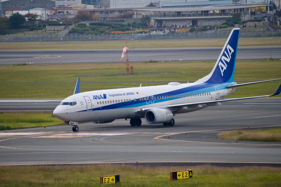 ANA airplane taxiing on runway at a Japanese airport, showcasing aviation travel.