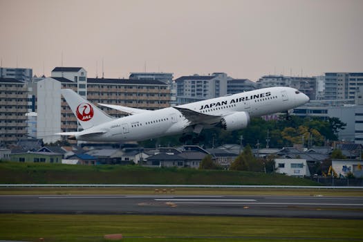 Japan Airlines Boeing 787 taking off at urban airport with cityscape background.