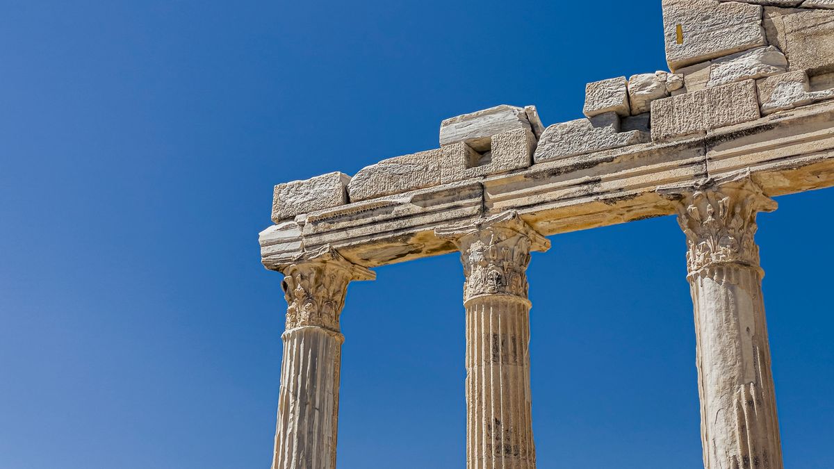 Close-up view of ancient Doric columns against a clear blue sky.