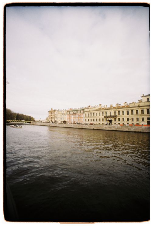 Free Scenic view of historic European buildings along a serene riverbank, showcasing architectural elegance. Stock Photo