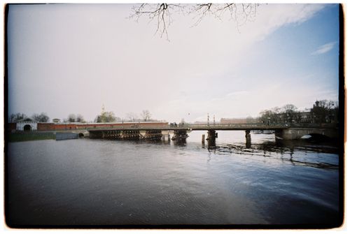 Free A picturesque view of a historic bridge spanning a calm river in early spring. Stock Photo