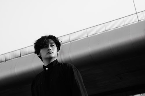 Free A moody black and white portrait of a person under a bridge, conveying introspection. Stock Photo