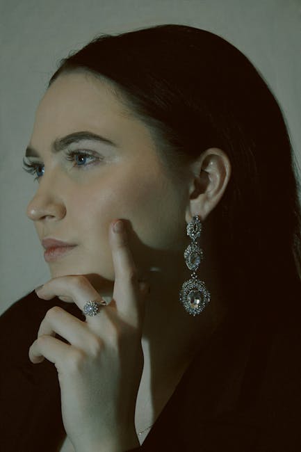 A thoughtful woman adorned with statement earrings and elegant jewelry.