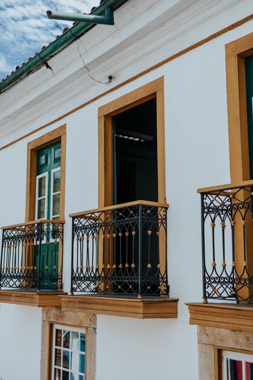 Free Detailed view of colonial building showcasing wrought iron balconies and traditional wood elements. Stock Photo