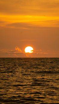 Beautiful sunset over ocean with vibrant orange hues reflecting on the water.