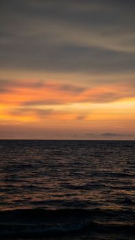 A mesmerizing scene of a serene sunset over the tranquil ocean, with vibrant warm colors.